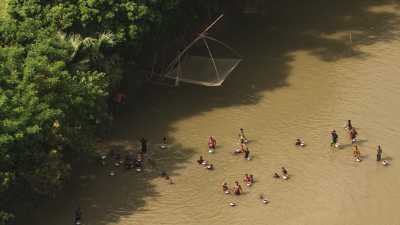 Hommes et enfants pêchant dans la rivière