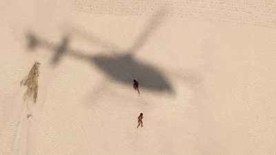 Enfants courant après l'ombre de l'hélicoptère
