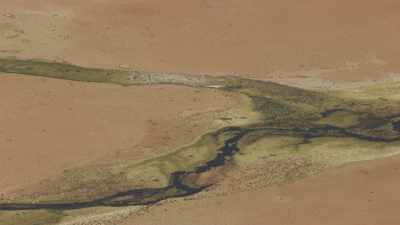 Rivière verte coulant sur une terre désertique