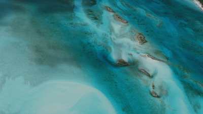 survol d'îlots, bancs de sable dans les eaux claires