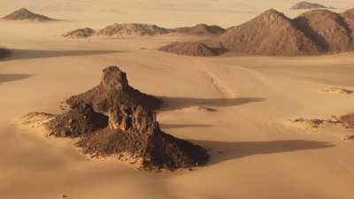 Un homme et ses dromadaires dans le désert rocheux de la région de Djanet
