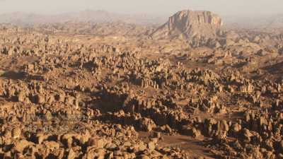 Dromadaires en groupe et leur berger, dans le désert rocheux de la région de Djanet