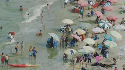 Gros plans sur la plage Martil et ses nombreux baigneurs, les parasols, les pédalos