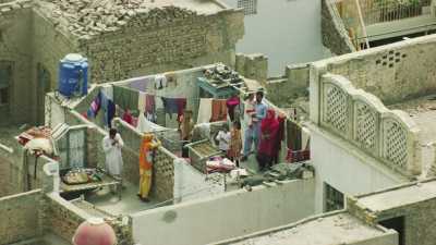 Des femmes font sécher la lessive colorée sur les toits de la ville