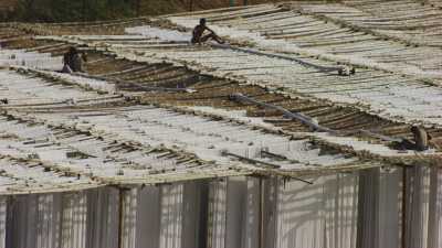 Zoom sur des ouvriers étendant les textiles dans une usine près de Karachi