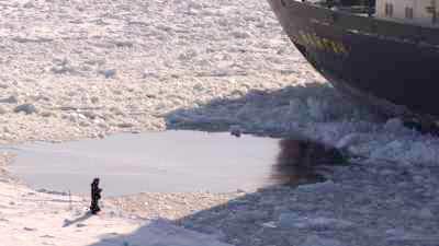 Enorme brise-glace et pêcheur sur le fleuve gelé Ienissei