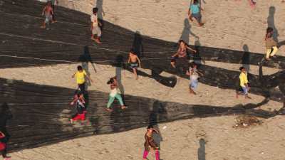 Enfants au milieu des filets de pêche sur la plage