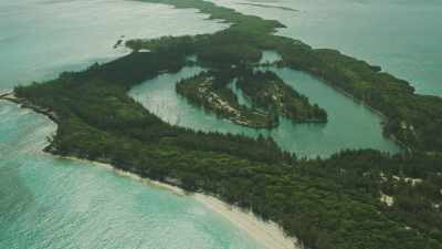 Survol d'un atoll en longueur, navire abandonné