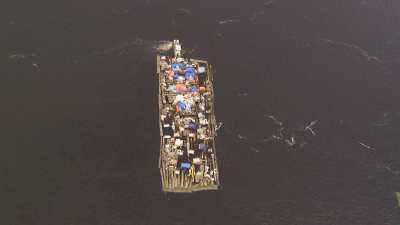 Une barge-radeau surchargée de transport de grumes