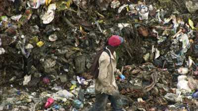 Homme suivi par une vague de déchets