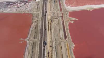 Une autoroute traverse les marais salants roses du lac Mariout