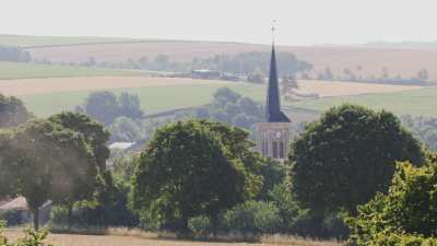 Tracteur qui laboure aux abords d'un village de campagne