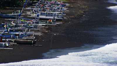 Chargement du riz en bateau  sur les plages de sable noir