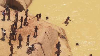 Jeux d'enfants dans les eaux jaunes de la rivière