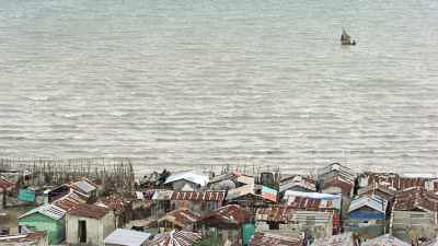 Le littoral de la Cité Soleil et ses barques, un bateau de pêche à la voile
